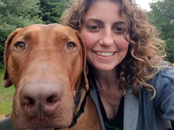 Friendly WAGS staff member with a happy golden retriever in-store